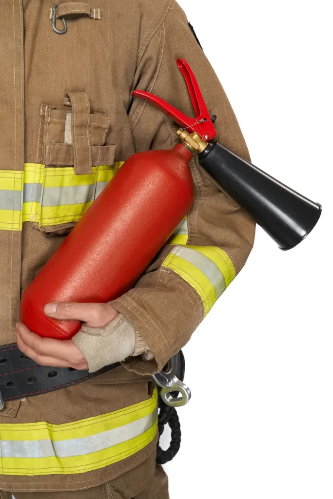 red extinguisher held by anonymous male firefighter